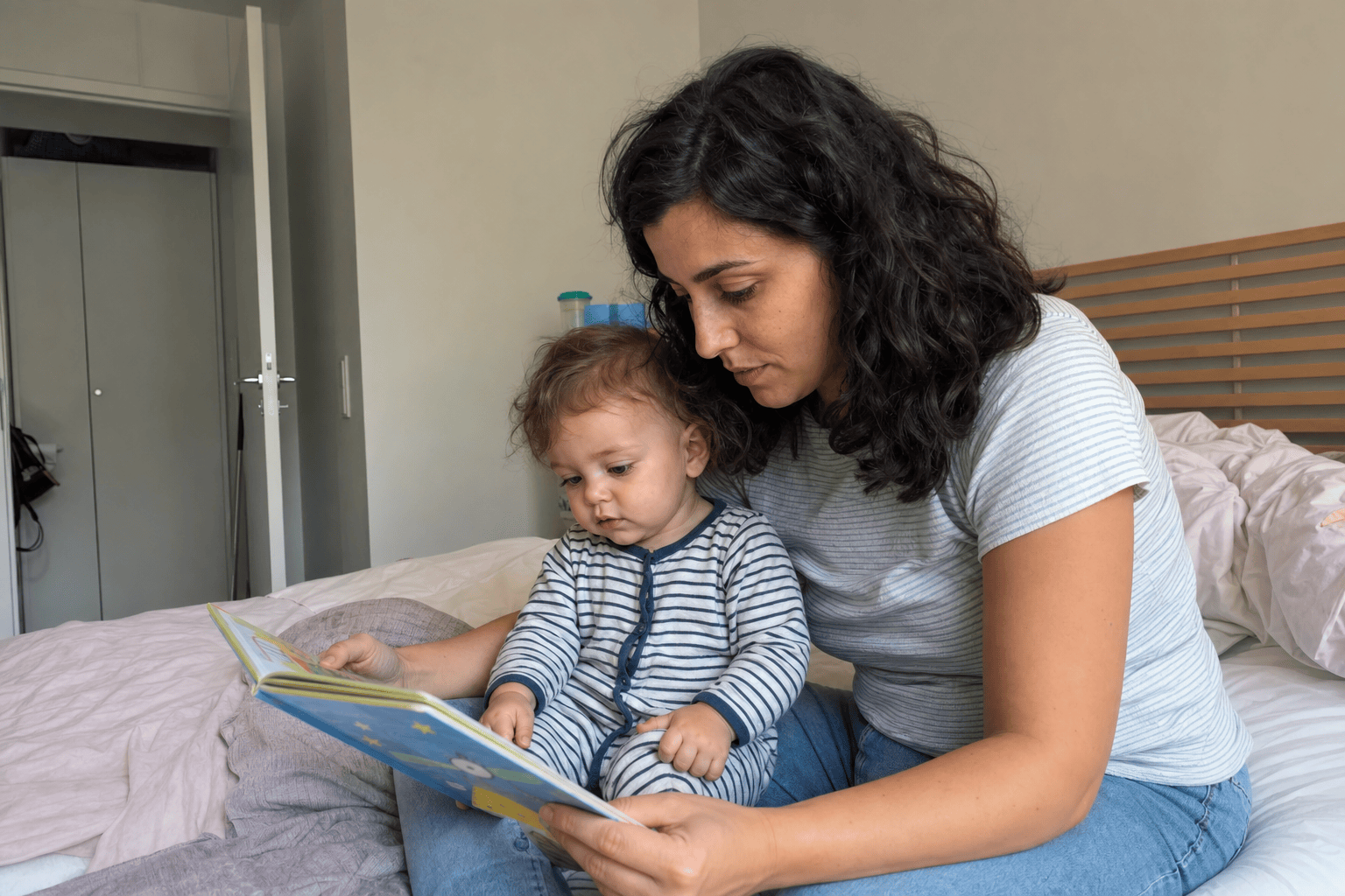 A parent reading a bedtime story to their toddler